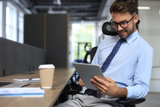 Young businessman using his tablet in the office