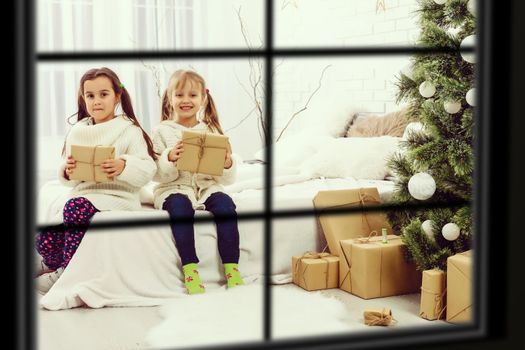 Big family with three children celebrating Christmas at home. Festive dinner at fireplace and Xmas tree. Parent and kids eating at fire place in decorated room. Child lighting advent wreath candle