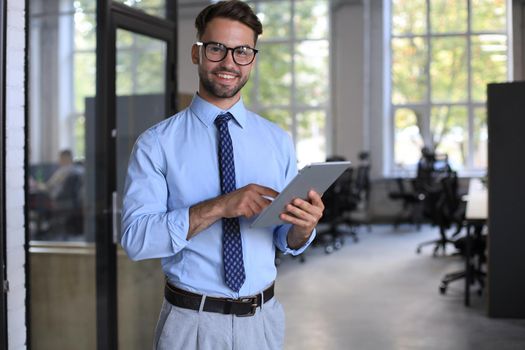 Young businessman using his tablet in the office