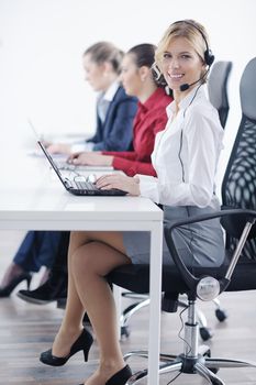 Pretty young business woman group with headphones smiling at you against white background