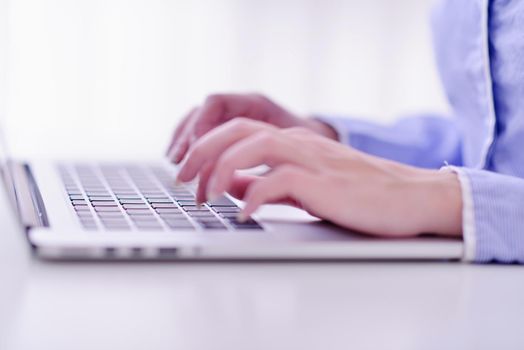 portrait of Young pretty business woman work on  notebook computer  in the bright modern office indoors