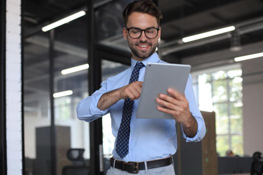 Young businessman using his tablet in the office