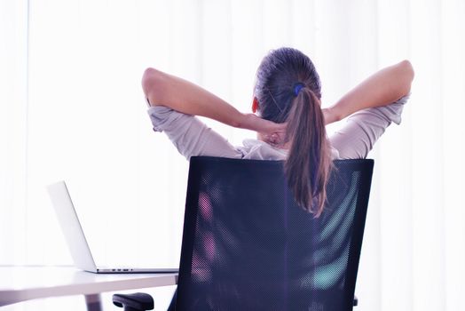 portrait of Young pretty business woman work on  notebook computer  in the bright modern office indoors