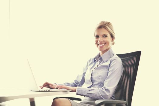 portrait of Young pretty business woman work on  notebook computer  in the bright modern office indoors