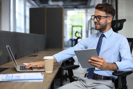 Young businessman using his tablet in the office