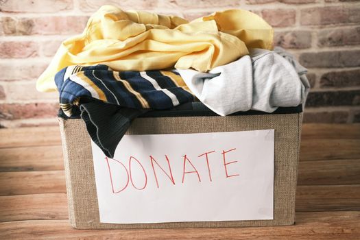 Donation box with donation clothes on a wooden background