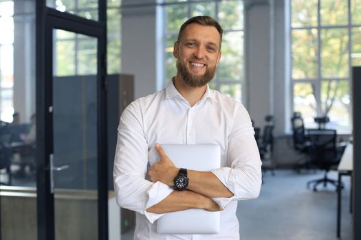 Young handsome businessman smiling in an office environment