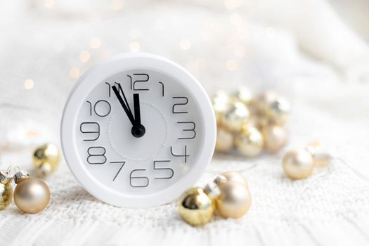 A clock on the beach with a garland . A white watch. Cozy vibes . Home comfort. New Year and Christmas. Decorating