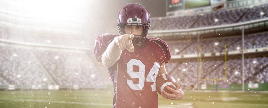 Portrait of American football player pointing against gray background