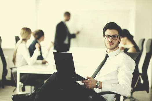 Portrait of a handsome young business man with people  in background at office meeting