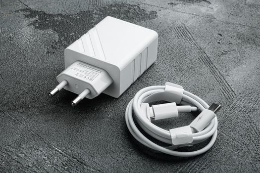 Adapter and USB Cable new package set, on gray stone table background