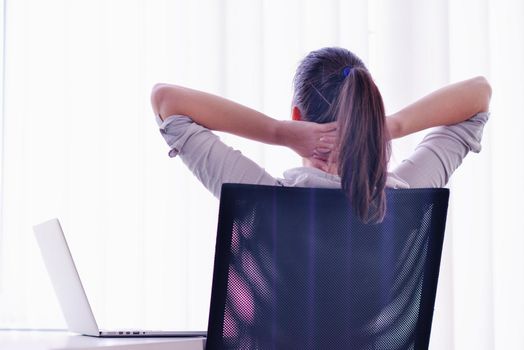 portrait of Young pretty business woman work on  notebook computer  in the bright modern office indoors