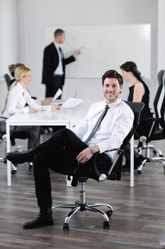 Portrait of a handsome young business man with people  in background at office meeting