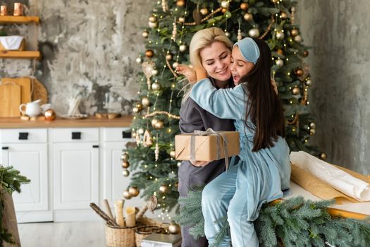 family, children, christmas, x-mas and happy people concept - hugging mother and daughter.