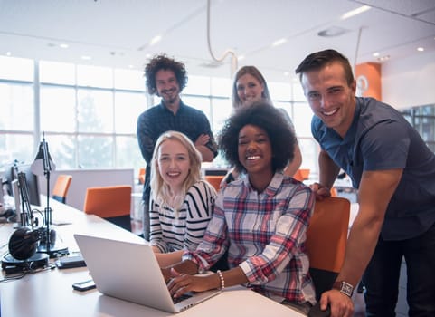 Multiethnic startup business team on meeting in modern bright office interior brainstorming, working on laptop