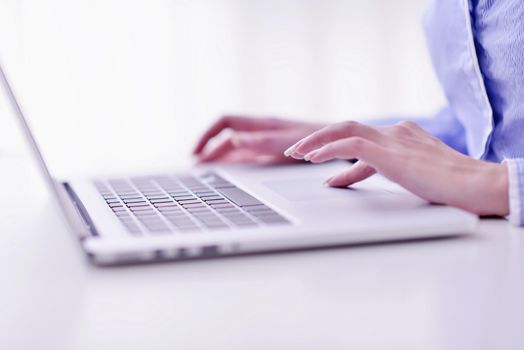 portrait of Young pretty business woman work on  notebook computer  in the bright modern office indoors