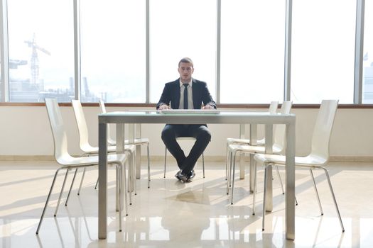 young business man lawyer with laptop alone in big bright   conference room