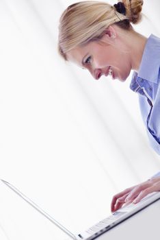 portrait of Young pretty business woman work on  notebook computer  in the bright modern office indoors