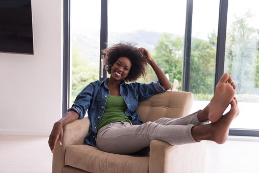 Young african american woman at home in the chair relaxing in her luxury home