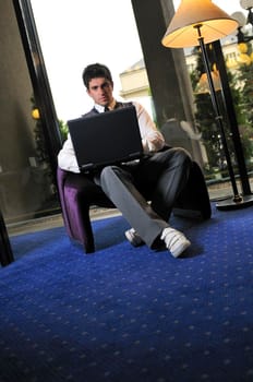 Happy young man sitting relaxed working on computer