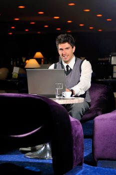 Happy young man sitting relaxed working on computer