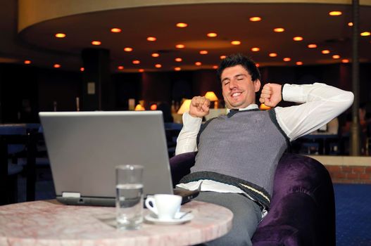 Happy young man sitting relaxed working on computer