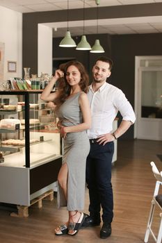 Woman wearing dress and man in white shirt standing at cafe. Concept of occupation and business, successful young people.