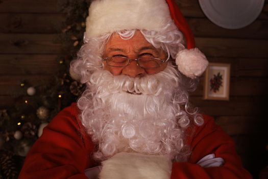 Traditional Santa Claus standing by the Christmas tree in a room
