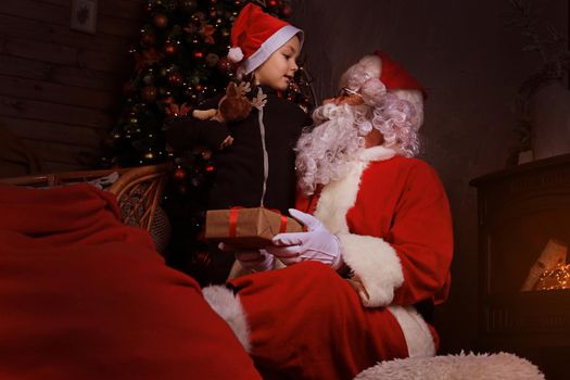 Santa Claus and child at home. Christmas gift. Family holiday concept