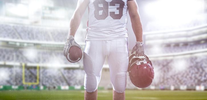 Closeup Portrait of a strong muscular American Football Player on big modern stadium field with lights and flares