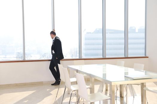 young business man lawyer with laptop alone in big bright   conference room