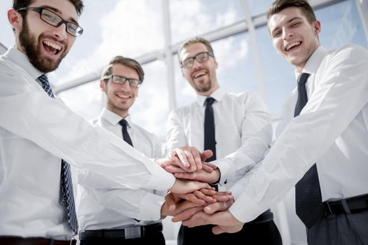 professional business team folding their hands together teamwork concept