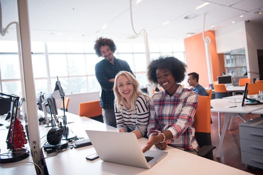 Multiethnic startup business team on meeting in modern bright office interior brainstorming, working on laptop