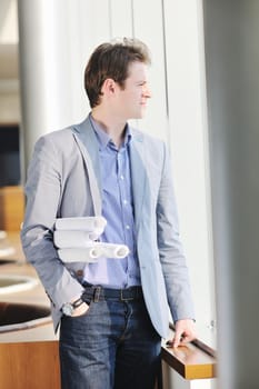 happy young architect business man portrait with paper blueprints plan