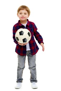 A sporty little boy is playing with a soccer ball. Concept of a healthy lifestyle, sport and fitness. Isolated on white background.