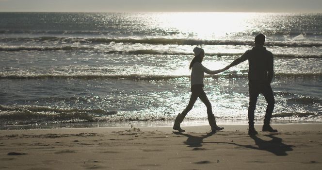 Romantic Couple Relaxing On The Beach during autumn day