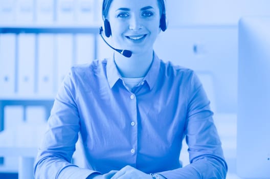 Serious pretty young woman working as support phone operator with headset in office.