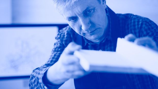 Architect working on drawing table in office.
