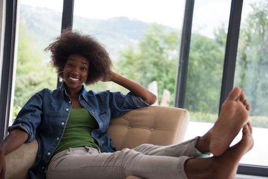 Young african american woman at home in the chair relaxing in her luxury home