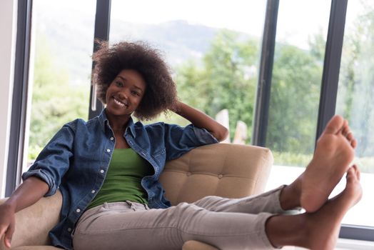 Young african american woman at home in the chair relaxing in her luxury home