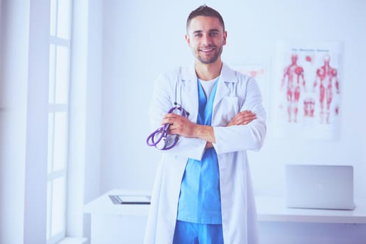 Young and confident male doctor portrait standing in medical office