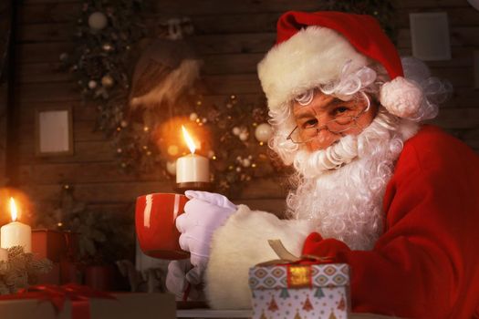 Santa Claus having a rest in a comfortable chair near the fireplace at home
