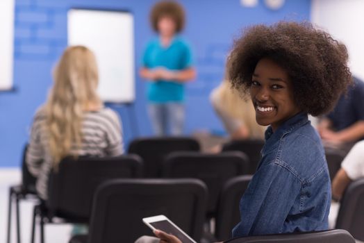 portrait of young African American business woman at modern startup office interior, team in meeting in background