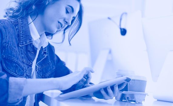 Young woman using digital tablet at office