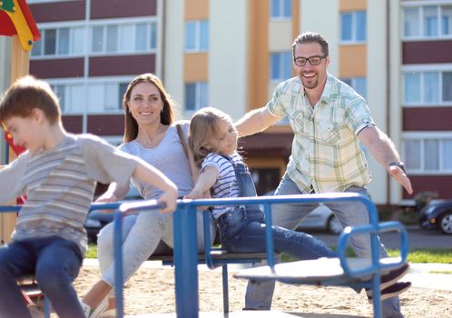 modern young family with children playing in the Playground.family holiday concept