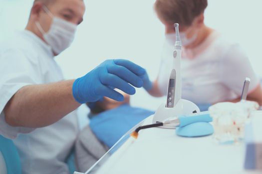 Detail of hand holding dental tools in dental clinic. Dentist Concept.