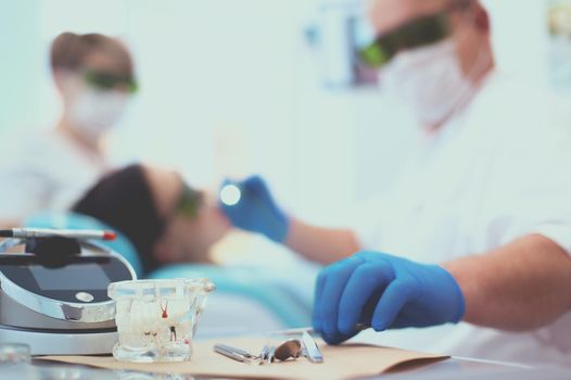 Senior male dentist adjust searchlight before starting work.