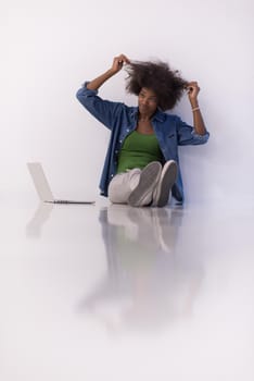 Portrait of happy young african american woman sitting on floor with laptop