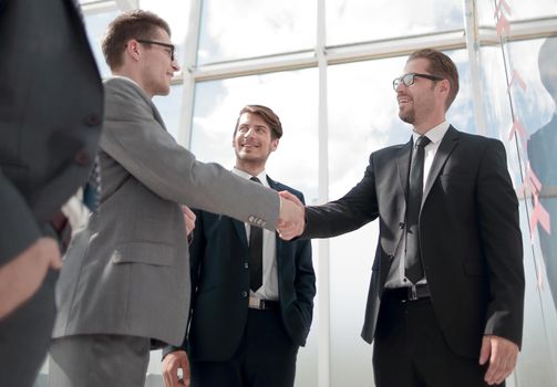 handshake business partners standing in a modern office. the concept of cooperation