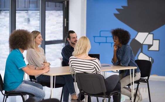 Multiethnic startup business team on meeting in modern bright office interior brainstorming, working on laptop and tablet computer